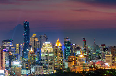 Illuminated buildings in city against sky at night