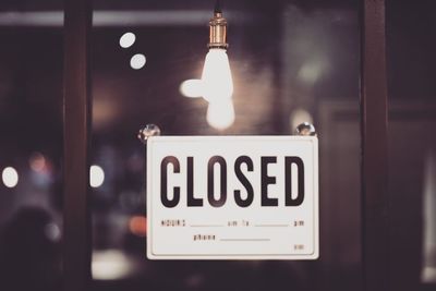 Close-up of closed sign on window