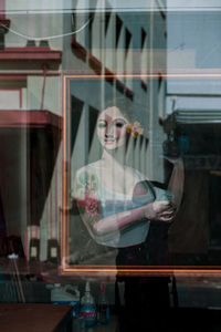 Portrait of woman standing by window