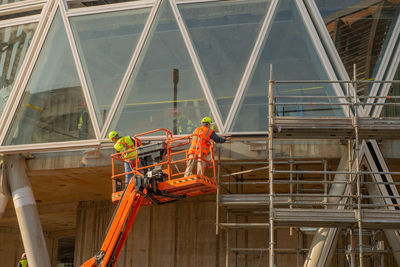 Workers on a platform in mobile safety while installing the electrical system at the library 