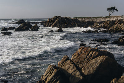 Scenic view of rocks in sea against sky