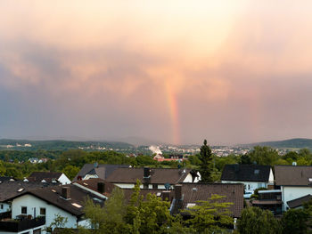 Scenic view of rainbow over buildings in city against sky