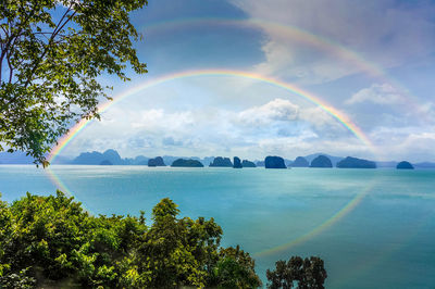 Scenic view of rainbow over sea against sky