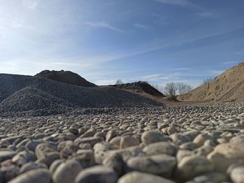 Surface level of stones on land against sky