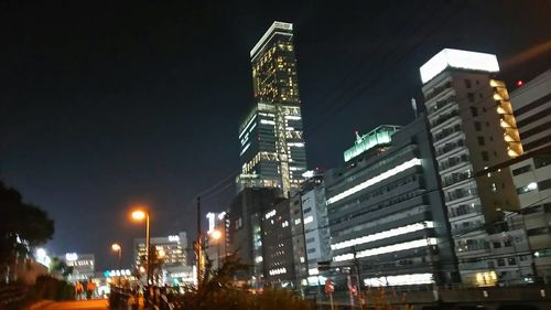 Illuminated cityscape against sky at night