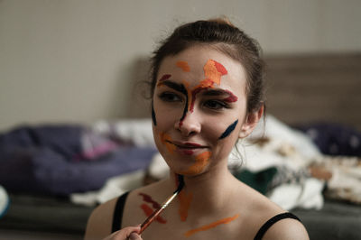 Close-up of young woman applying body paint