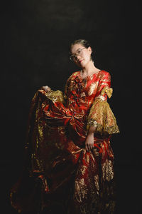 Woman looking away against black background