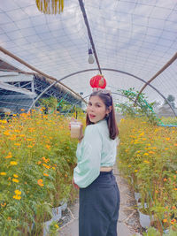 Portrait of woman standing amidst plants