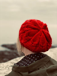 Rear view of a woman wearing a red knit hat in winter