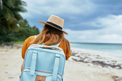 Rear view of woman wearing hat on beach