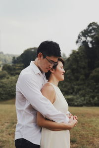 Side view of young couple standing on field