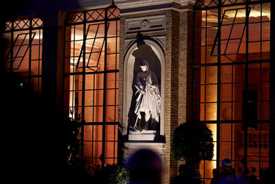 Statue against illuminated building