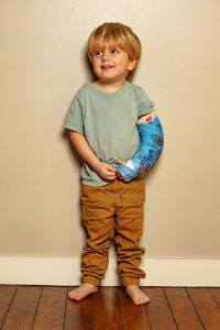 Portrait of boy standing against wall