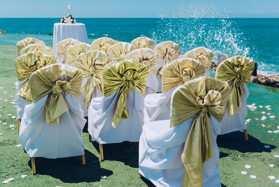 Decorated empty chairs at beach during wedding