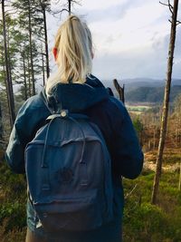 Rear view of woman standing in forest