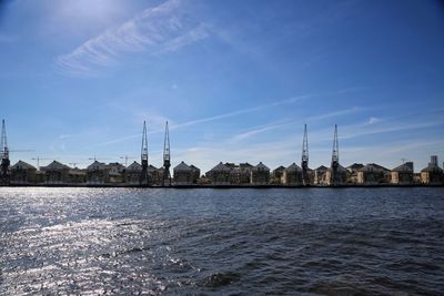 Bridge over river by city against sky