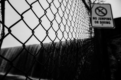 Close-up of chainlink fence against sky