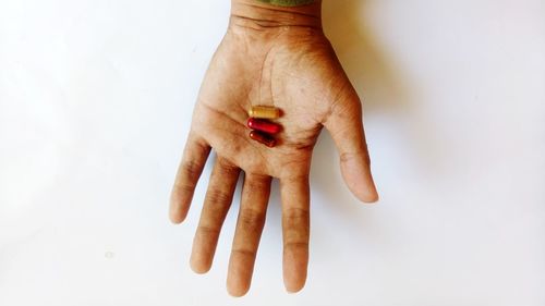 Directly above shot of hand holding ice cream over white background