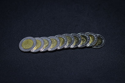 Close-up of coins on table against black background