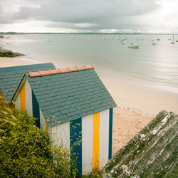 Scenic view of beach and beach huts against sky