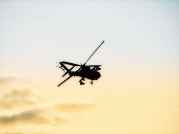 Low angle view of silhouette helicopter against sky