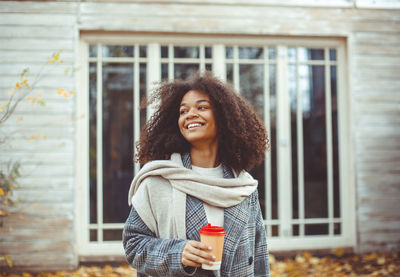 Young woman standing against window