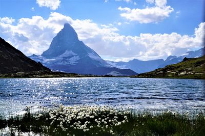 Scenic view of lake and snowcapped mountains against sky