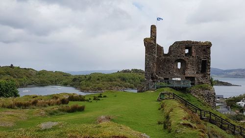 Castle by lake against sky