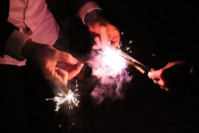 Midsection of man burning sparklers