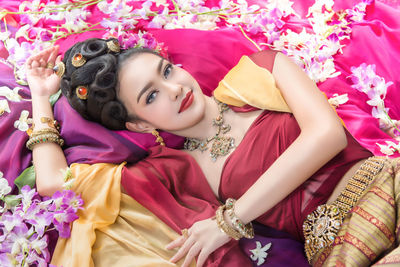 Portrait of young woman lying on bed