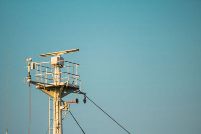 Low angle view of crane against clear blue sky