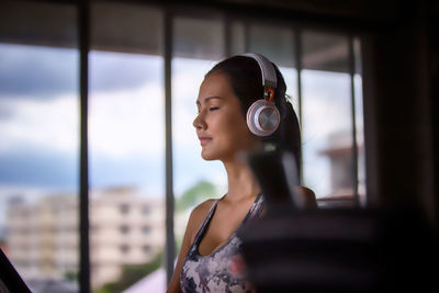 Young woman listening music in gym