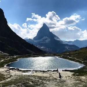 Scenic view of lake by mountains against sky