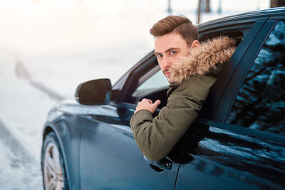 Portrait of young man in car