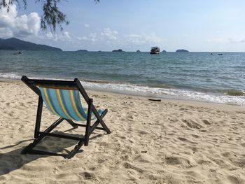 Chairs on beach against sky