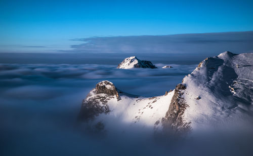 Scenic view of sea and snowcapped mountains against sky