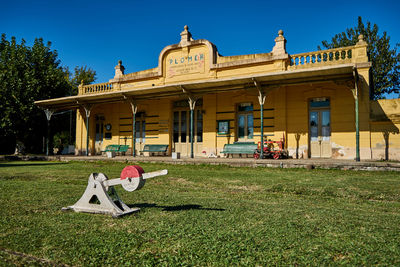 Traditional building on field against clear sky