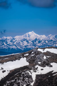 Scenic view of snowcapped mountains against blue sky