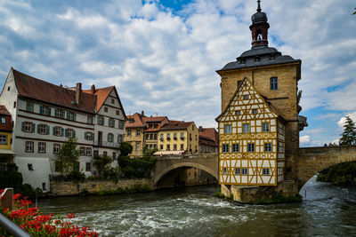 Arch bridge over river against buildings in city