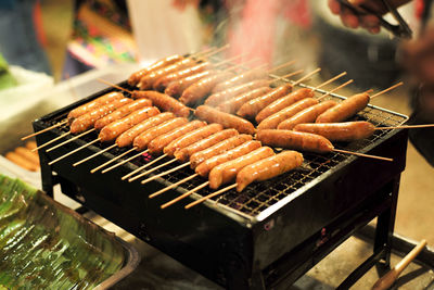 Close-up of sausages on barbecue grill with smoke