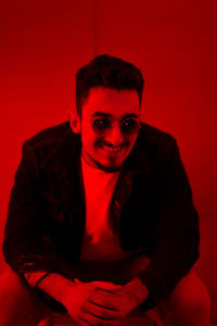 Close-up portrait of mid adult man against red background