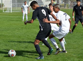 Men playing soccer on field