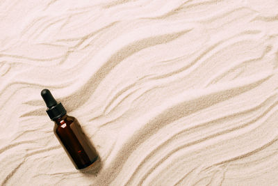 High angle view of bottles on sand