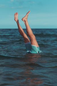 Low section of young woman in sea