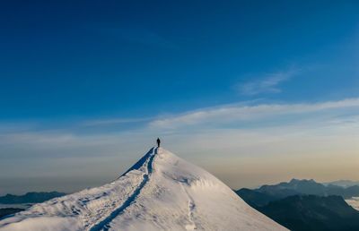 Scenic view of snowcapped mountains against blue sky