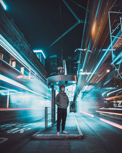 Full length of man standing on illuminated railroad station platform