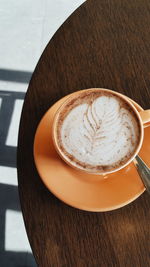 High angle view of cappuccino served in coffee cup on table