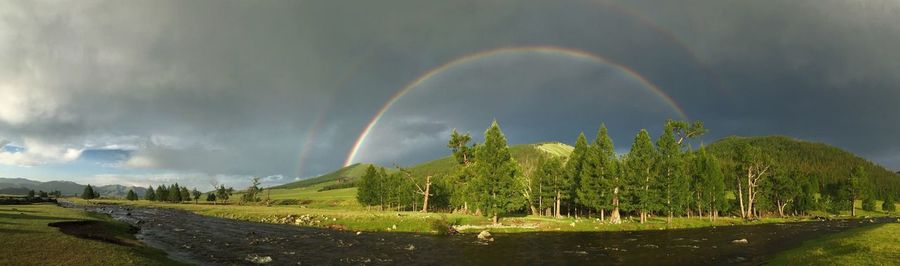 Panoramic view of rainbow over mountain against sky