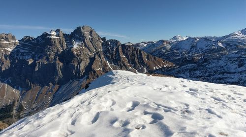Scenic view of mountains against clear sky during winter