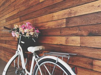 Close-up of bicycle leaning on wooden wall